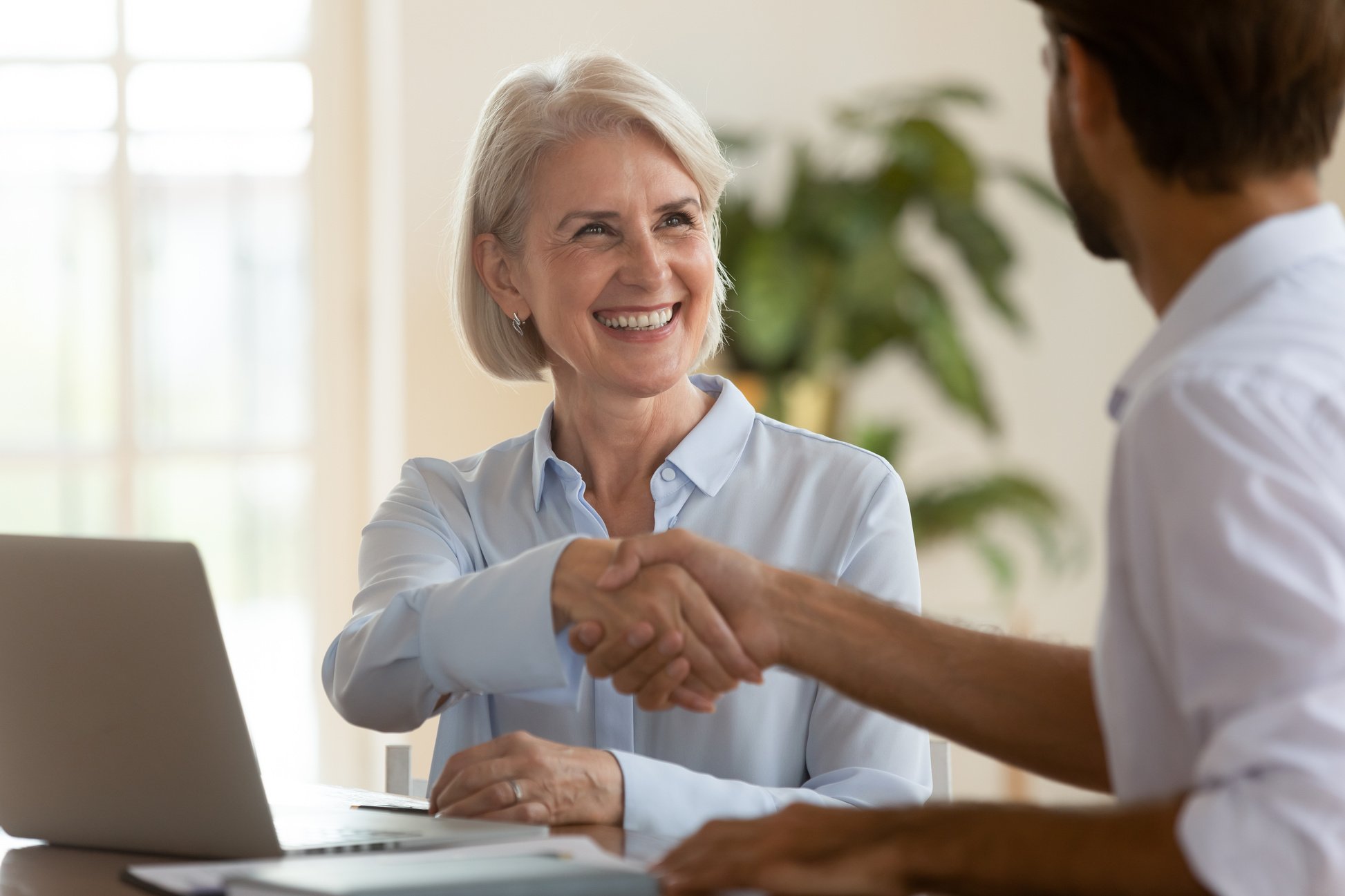 Mature Saleswoman Shake Hands with Male Client 